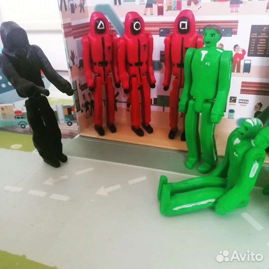 Кукла и игроки из игры в Кальмара