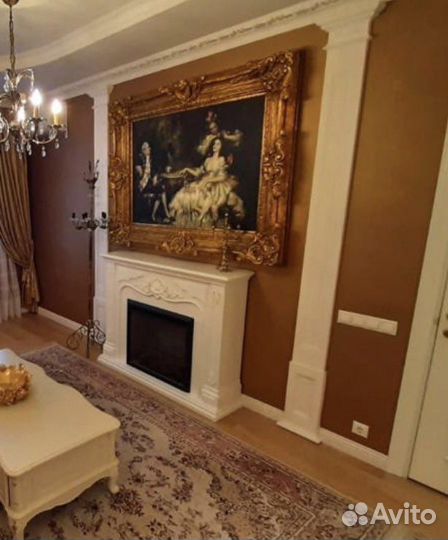 Картина в золотой раме и журнальный стол