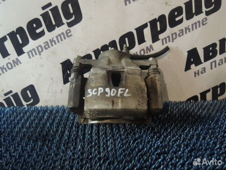 Суппорт тормозной передний левый Toyota Vitz SCP90