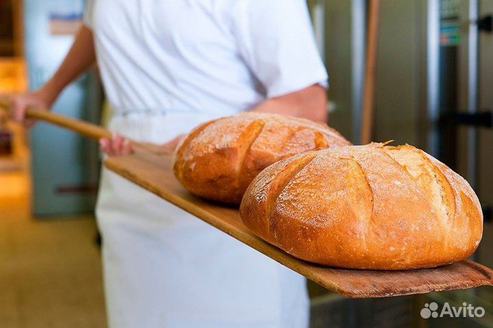 Рабочий с тестом в пекарню